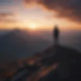 Silhouette of a person standing on a mountain peak at sunrise