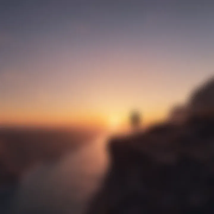 Silhouette of a person standing alone on a cliff edge at sunset